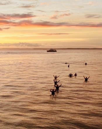 Viajeros en el agua al atardecer, con el Sibon Jaya al fondo